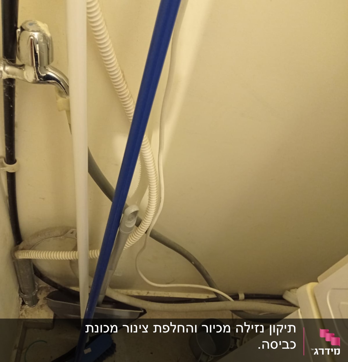 צינורות מים וניקוז ליד מכונת כביסה